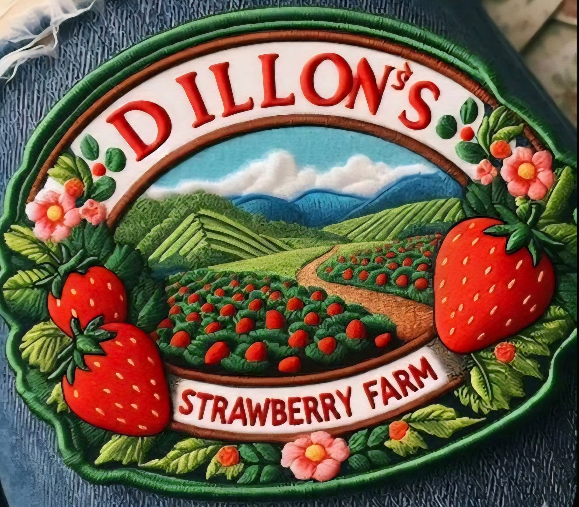 Oval sign for Dillon's Strawberry Farm featuring a scenic landscape with strawberries, flowers, and mountains.